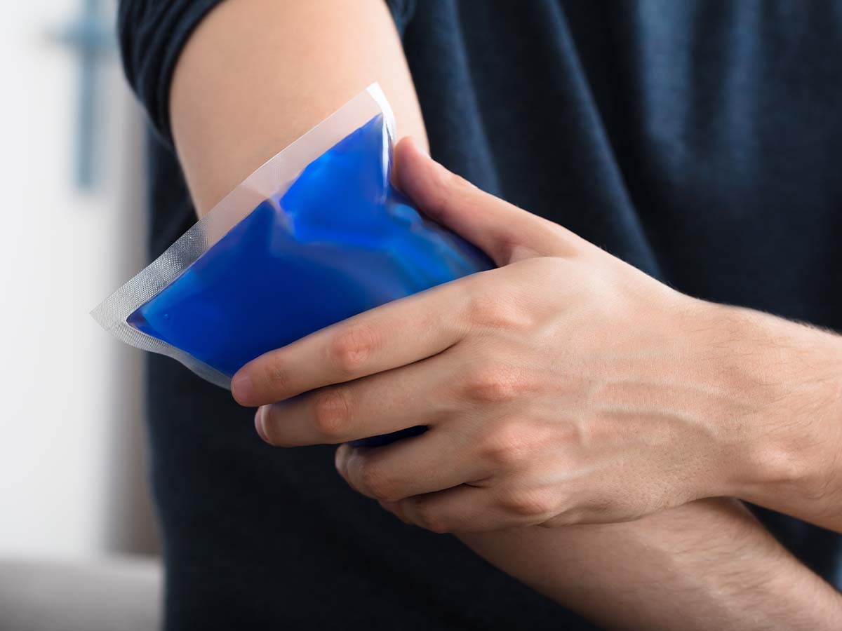 Person applying ice pack to elbow