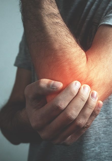 Man holding his elbow that is glowing red with pain
